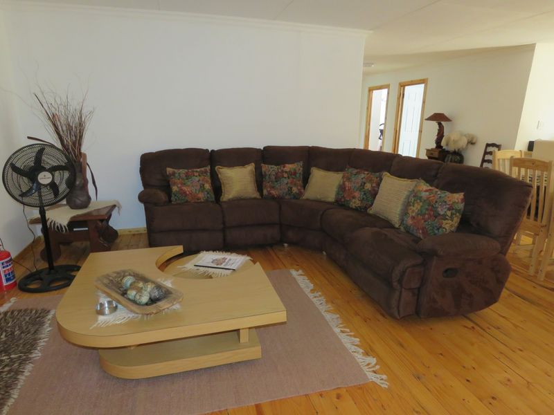A spacious living room featuring polished timber flooring and neutral walls, providing a comfortable and versatile area for relaxation.