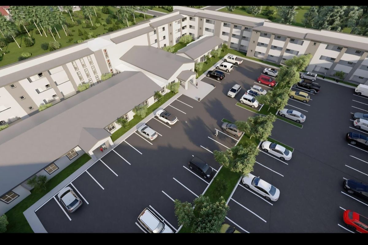 An aerial view of the retirement village complex, showcasing the building layout, parking facilities, and surrounding landscaped grounds.