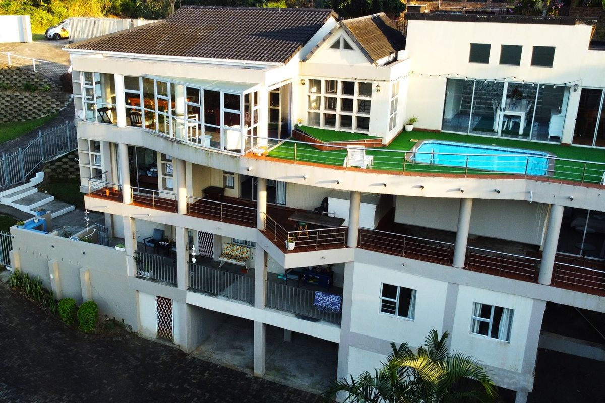 Aerial view of a multi-level residential property featuring a swimming pool, expansive balconies, and tiered outdoor living spaces.