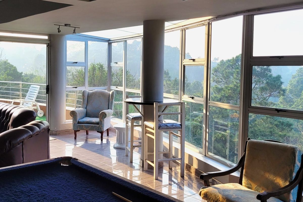 Spacious living area featuring extensive floor-to-ceiling windows that provide abundant natural light and scenic views of the surrounding landscape.