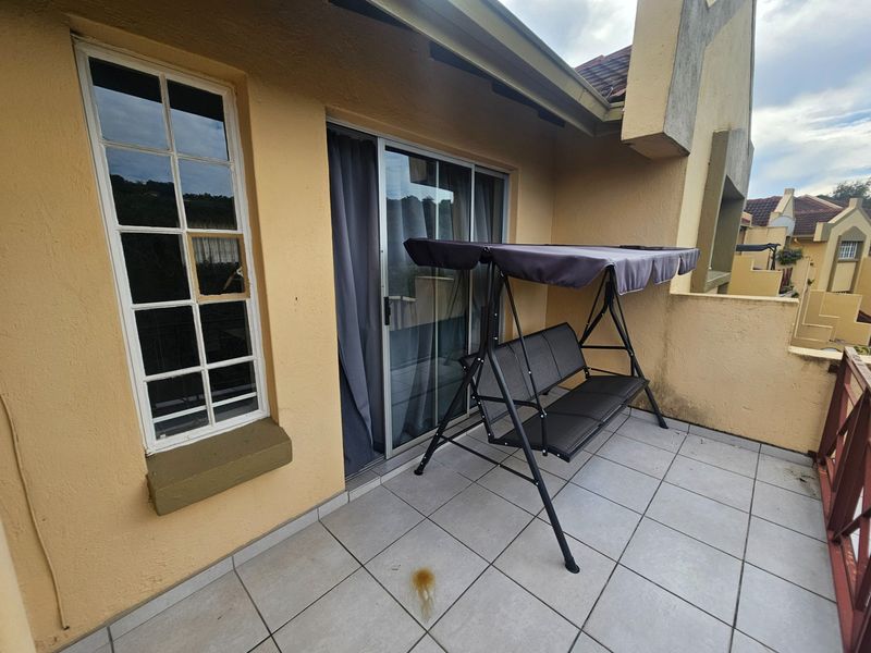 A private balcony featuring tiled flooring, sliding glass door access, and a window with a broken pane, requiring maintenance and repair.