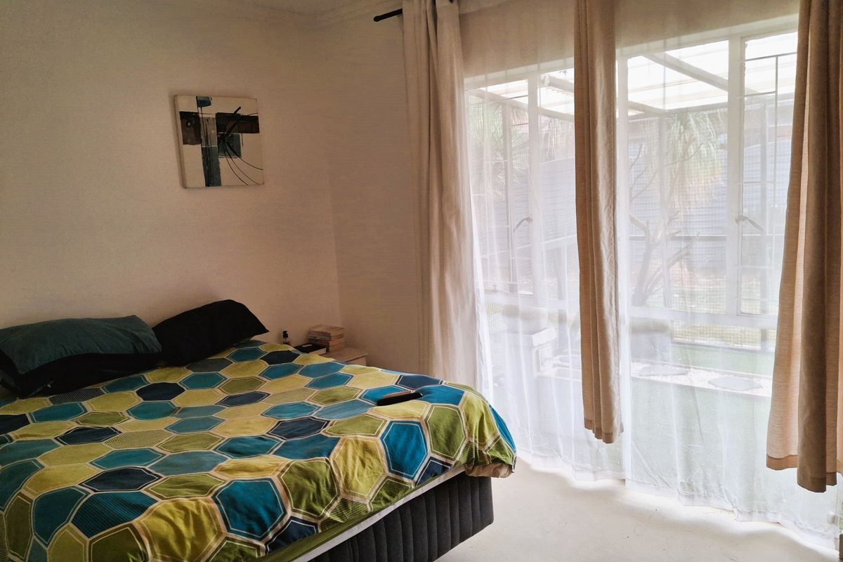 A bedroom featuring a large sliding glass door that provides natural light and access to an outdoor patio area.