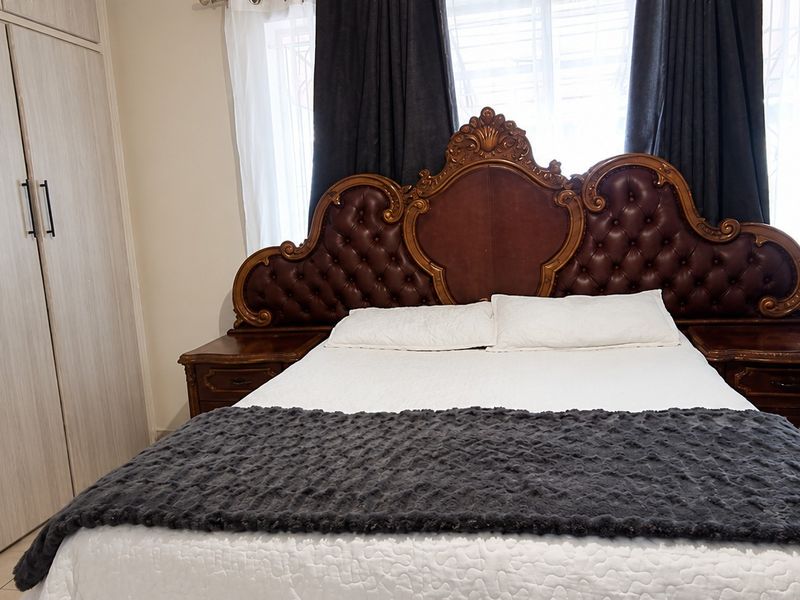 A well-maintained bedroom featuring light-toned built-in cupboards and neutral tiled flooring, providing a clean and functional living space.