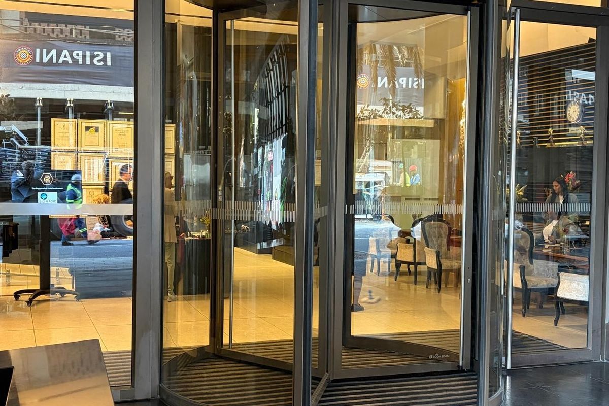 A modern revolving glass entrance door providing access to the retail space, featuring polished tile flooring and a clean, professional storefront aesthetic.