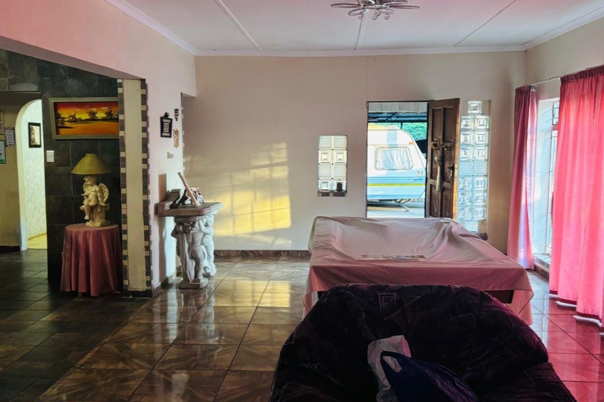 Spacious living area featuring tiled flooring, glass block accents, and direct access to the exterior, offering a versatile layout for family living.