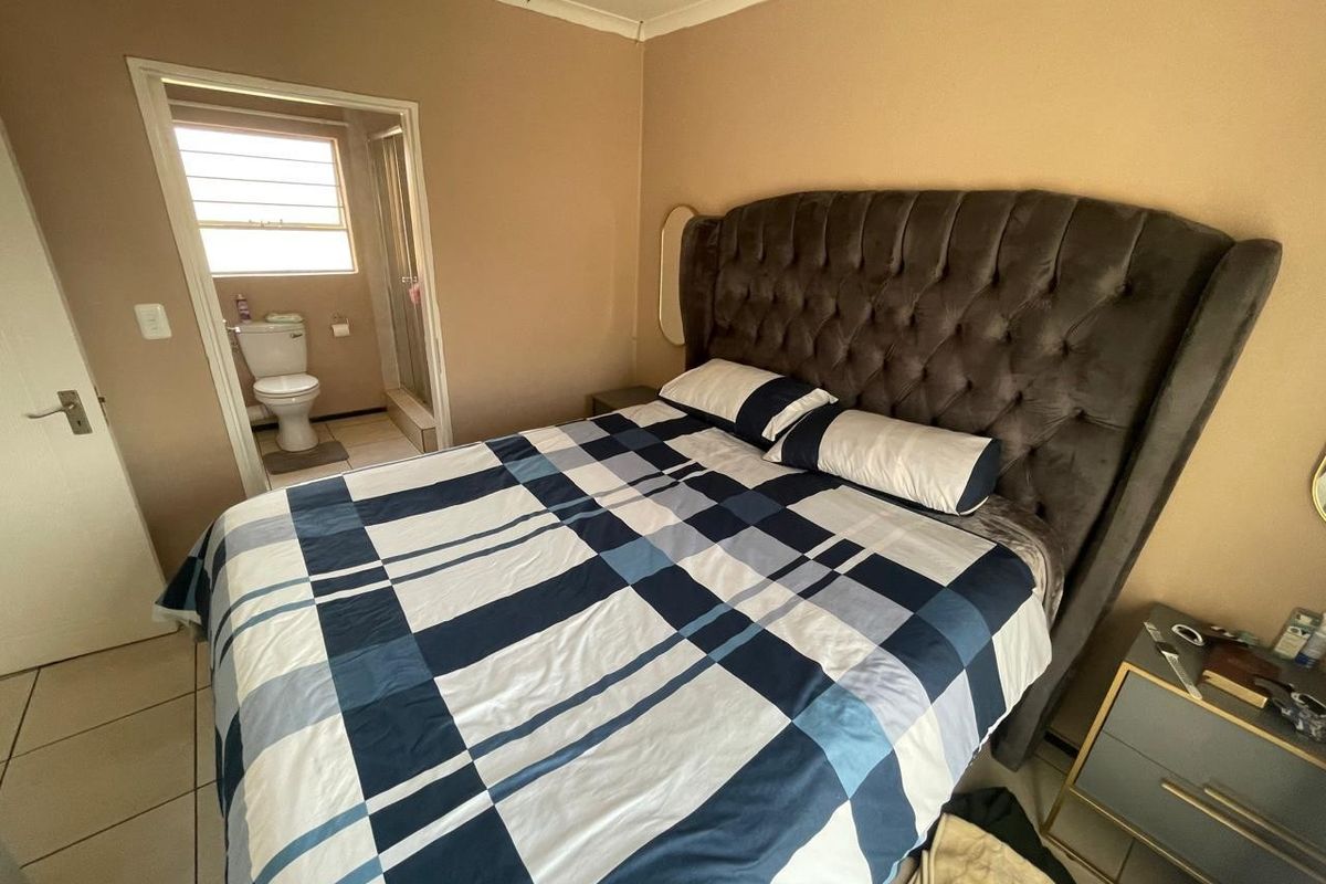 A bedroom featuring tiled flooring and an en-suite bathroom with a toilet and shower.