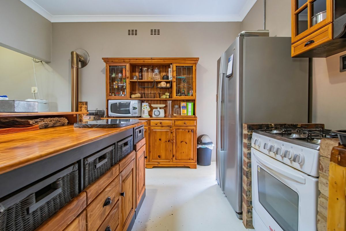 A rustic kitchen featuring wooden cabinetry, a built-in gas stove, and a central island with integrated storage.