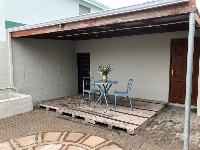 Covered outdoor patio area featuring a timber pergola structure and raised timber decking, providing a functional space for outdoor relaxation.