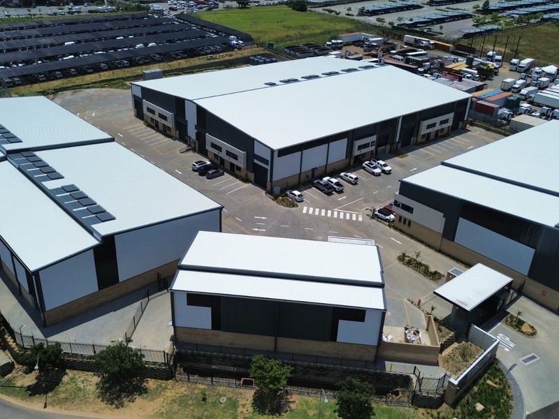 Aerial view of a modern industrial warehouse complex featuring multiple units, paved parking, and secure perimeter access.