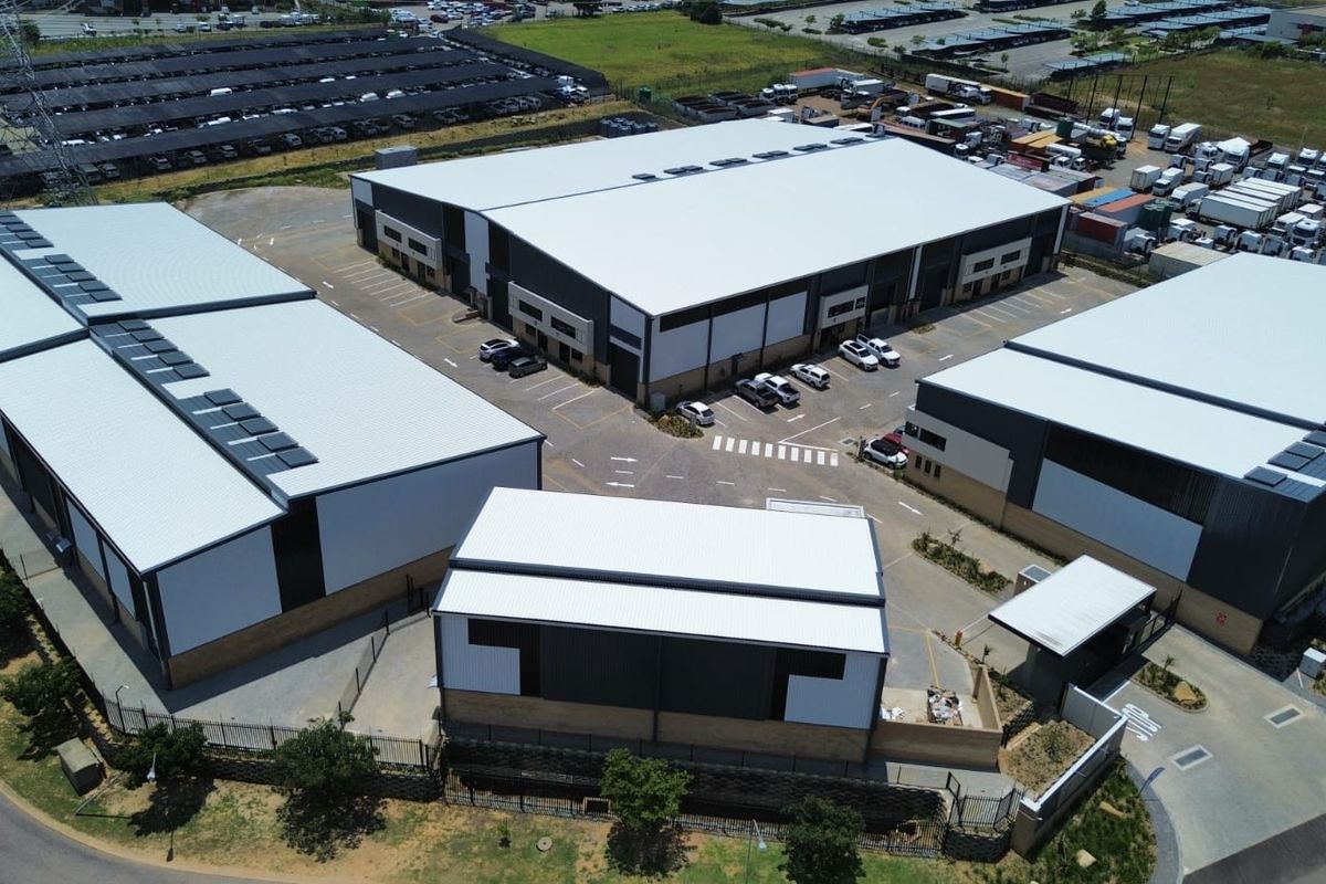 Aerial view of a modern industrial warehouse complex featuring multiple units, paved parking, and secure perimeter access.