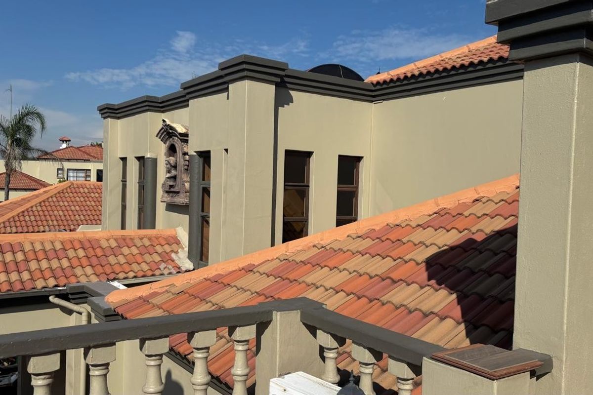 An elevated view of the property exterior, showcasing the terracotta tiled roof, rendered facade, and a decorative architectural niche.