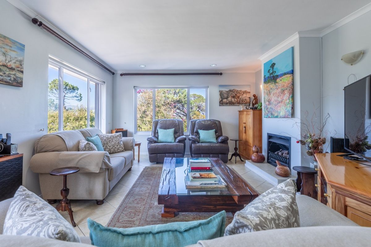 A bright and comfortable living room featuring a built-in fireplace, large windows providing natural light, and neutral tiled flooring.
