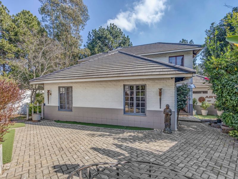 A view of the exterior side elevation featuring painted brickwork, tiled roofing, and a paved driveway area.