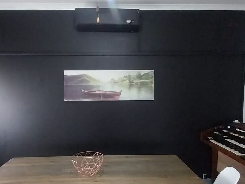A dining room featuring a dark accent wall, a wall-mounted air conditioning unit, and crown molding.
