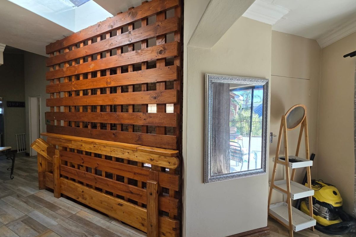 Interior view featuring a wooden lattice room divider and tiled flooring, creating a distinct separation between living spaces.