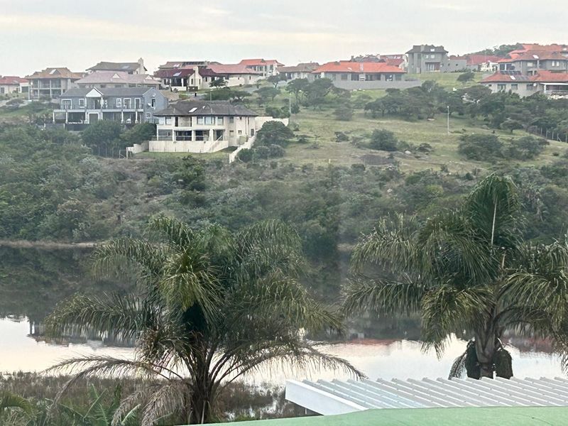 A scenic elevated view overlooking a tranquil lake and surrounding residential estate landscape.