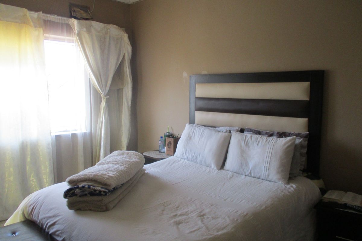 A standard bedroom featuring neutral wall tones and a window with natural light.
