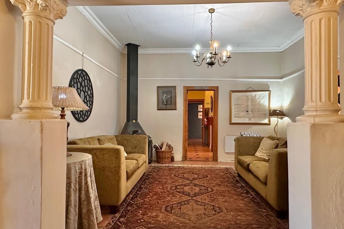 A cozy living area featuring a classic fireplace, decorative columns, and traditional architectural details, creating a warm and inviting atmosphere.