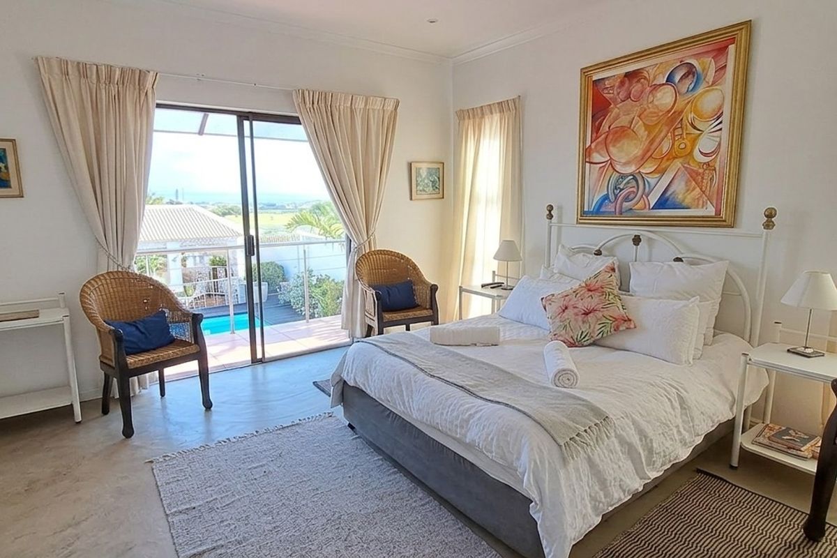 Spacious bedroom featuring neutral finishes, built-in cabinetry, and sliding glass doors providing direct access to a private balcony with outdoor views.