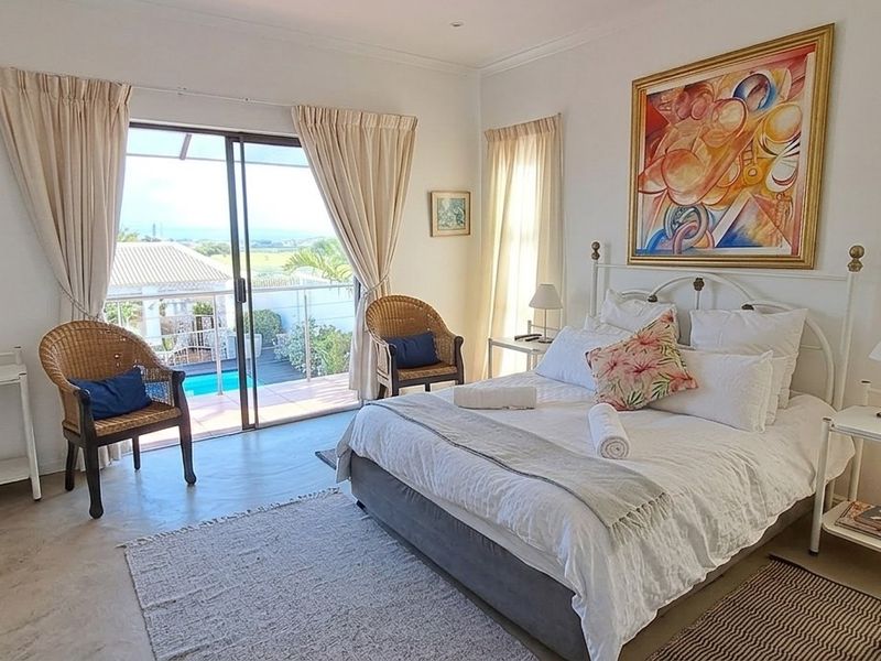 Spacious bedroom featuring neutral finishes, built-in cabinetry, and sliding glass doors providing direct access to a private balcony with outdoor views.