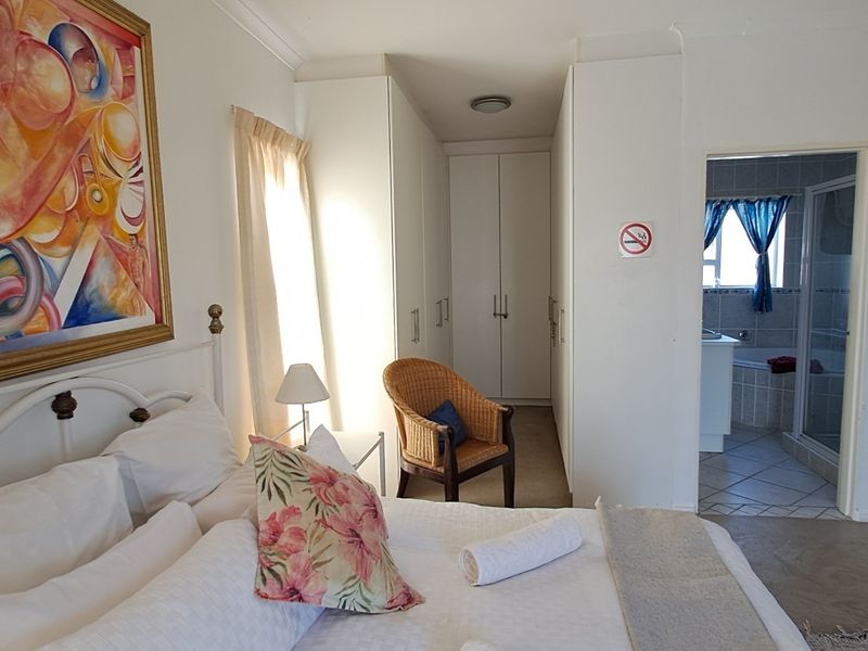 Spacious bedroom featuring built-in cupboards and direct access to an en-suite bathroom.