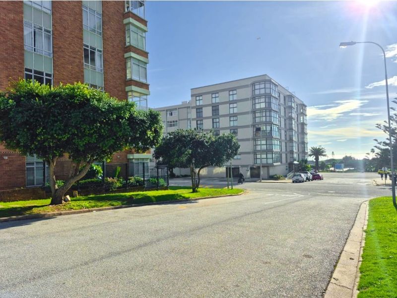 A street-level view of the apartment complex exterior, showcasing the surrounding neighborhood infrastructure and building facade.