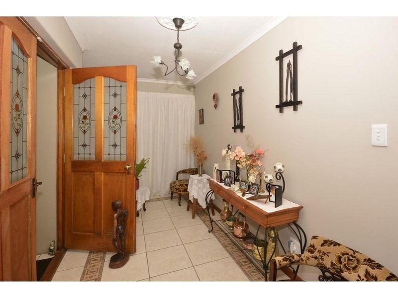 Welcoming entrance hall featuring ceramic floor tiles, a decorative ceiling rose, and a classic stained glass timber door.