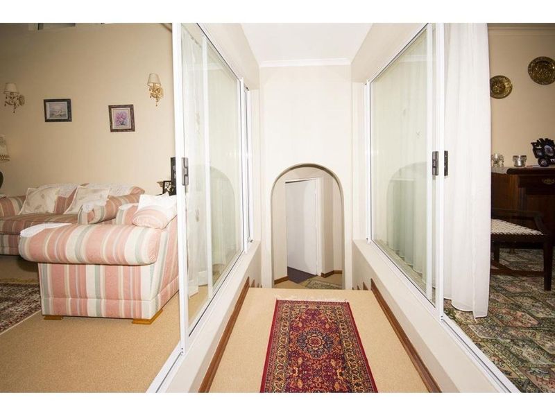 A central hallway featuring sliding glass partitions on both sides and an arched doorway leading to an adjacent room.