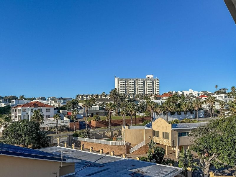 An elevated view overlooking the surrounding residential neighborhood and urban landscape under a clear blue sky.