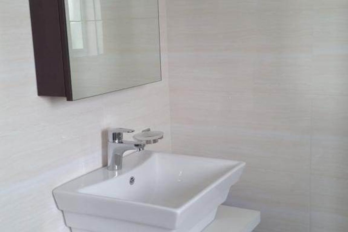 A modern bathroom vanity featuring a white vessel sink, chrome faucet, dark wood cabinetry, and a wall-mounted mirror with integrated lighting.