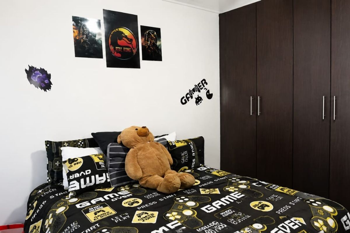 A bedroom featuring dark wood-finish built-in cupboards and white walls, providing ample storage space.