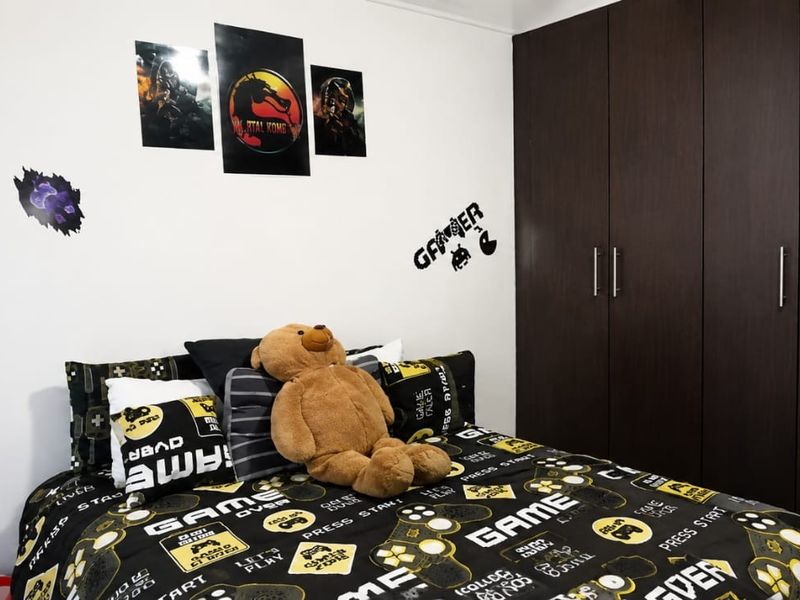 A bedroom featuring dark wood-finish built-in cupboards and white walls, providing ample storage space.