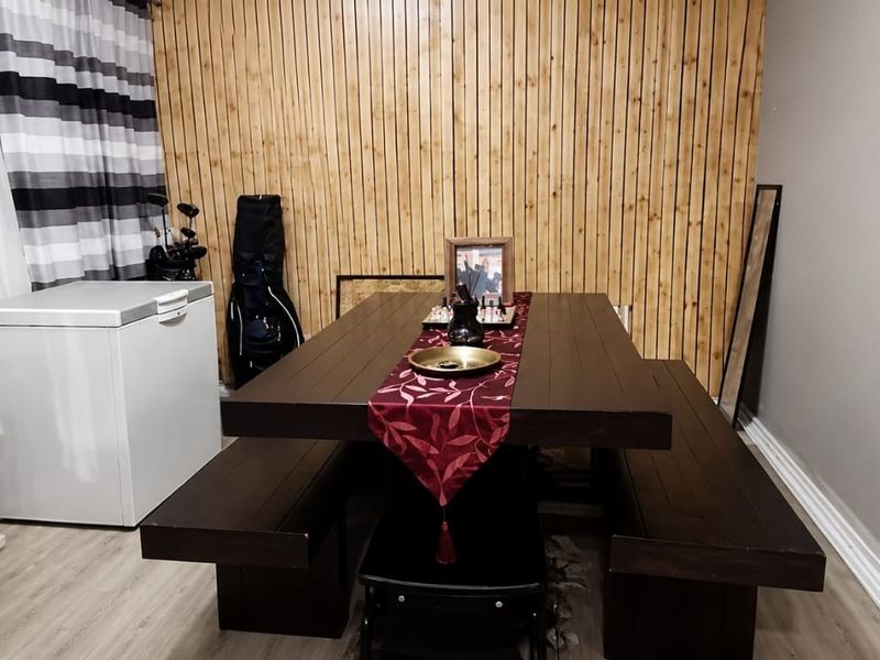 Dining area featuring timber slat wall paneling and light-toned laminate flooring, providing a neutral foundation for interior design updates.