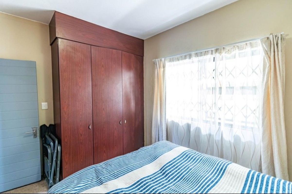 A bedroom featuring built-in wooden cabinetry and a window with natural light.