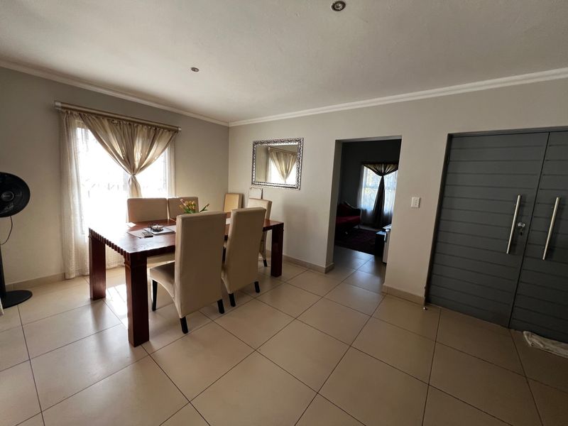 A dining area featuring tiled flooring, recessed ceiling lighting, and a doorway leading to an adjacent living space.