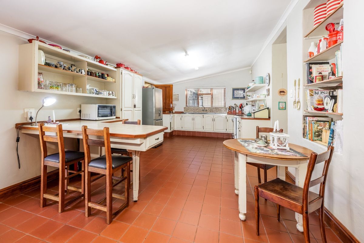 Spacious kitchen featuring built-in cabinetry, tiled flooring, and a breakfast nook area with integrated shelving.