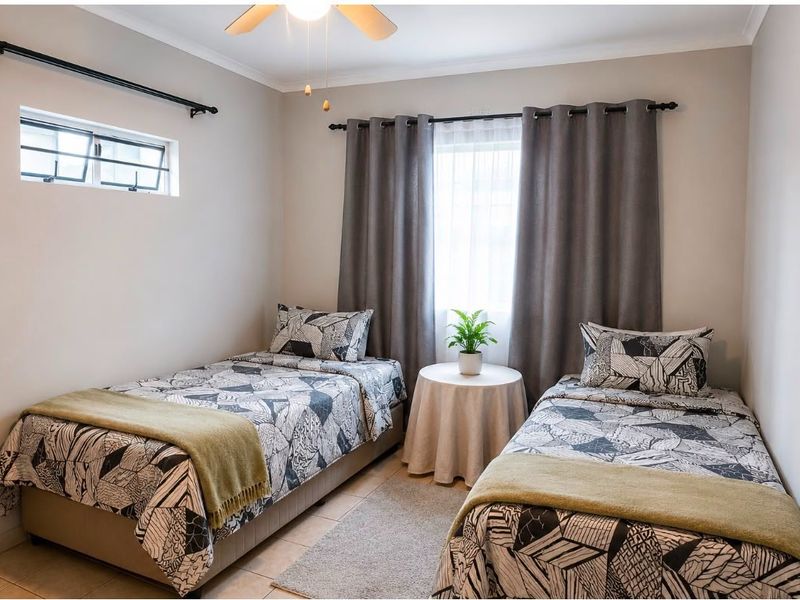 A well-maintained bedroom featuring tiled flooring, a ceiling fan, and dual windows with curtain rods, providing a bright and functional living space.