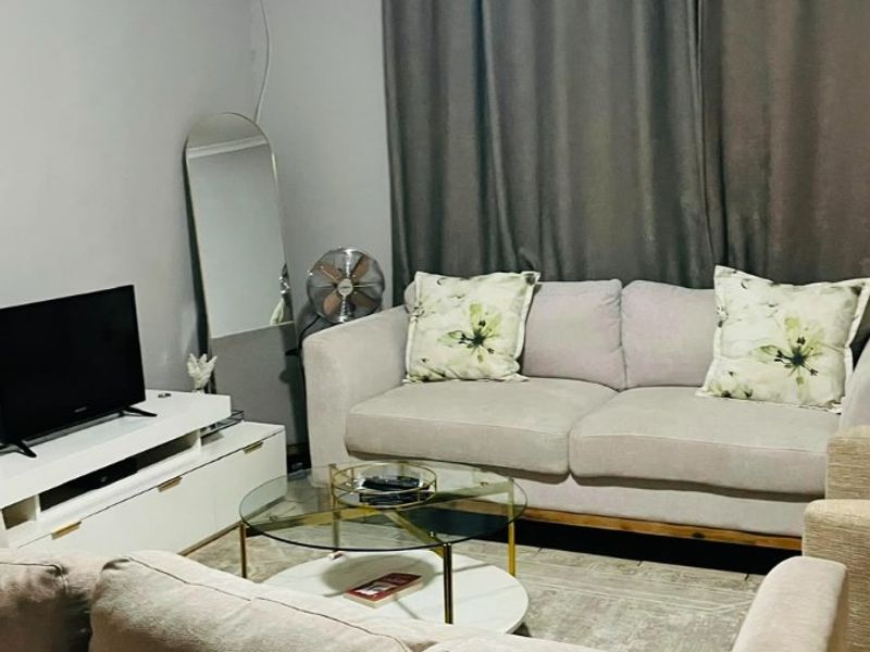 A comfortable living room featuring a ceiling fan and neutral wall finishes, providing a functional and inviting space for relaxation.