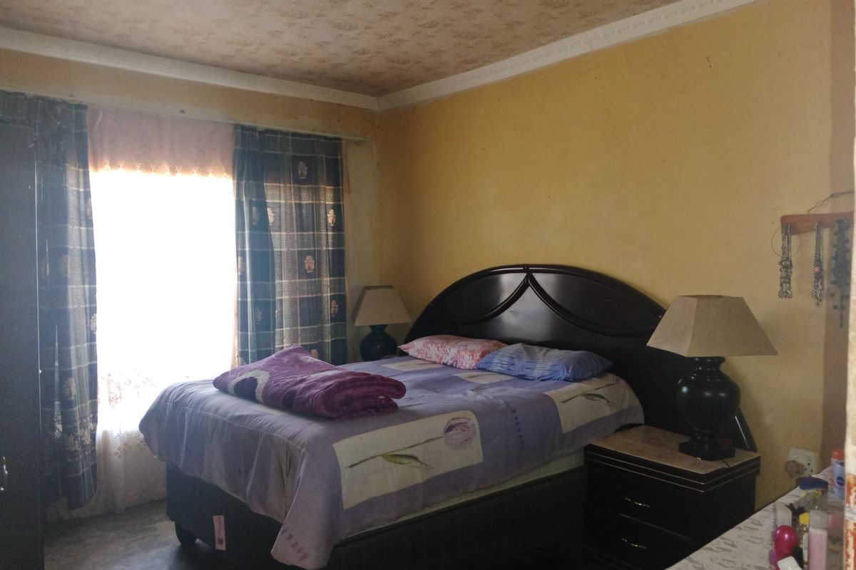 A bedroom featuring dated wall finishes and ceiling textures, offering a blank canvas for potential cosmetic updates and modernization.