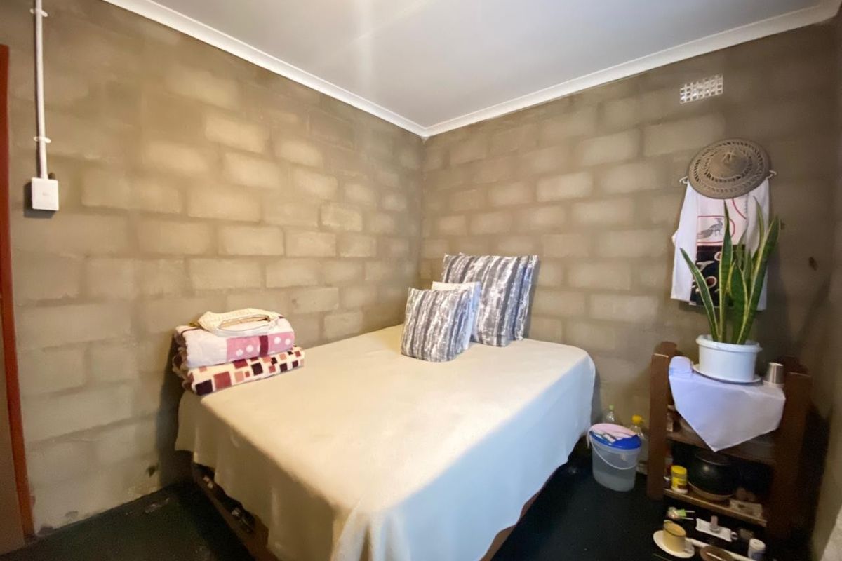 A bedroom featuring exposed concrete block walls and basic finishes, offering a blank canvas for potential renovation and interior design updates.