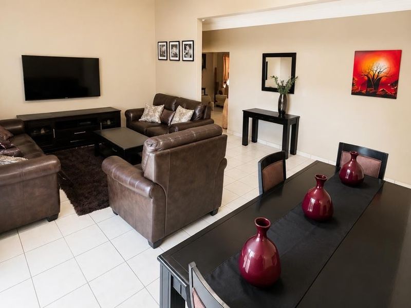 An open-plan living and dining area featuring neutral wall tones and tiled flooring, providing a functional and connected space for daily living.