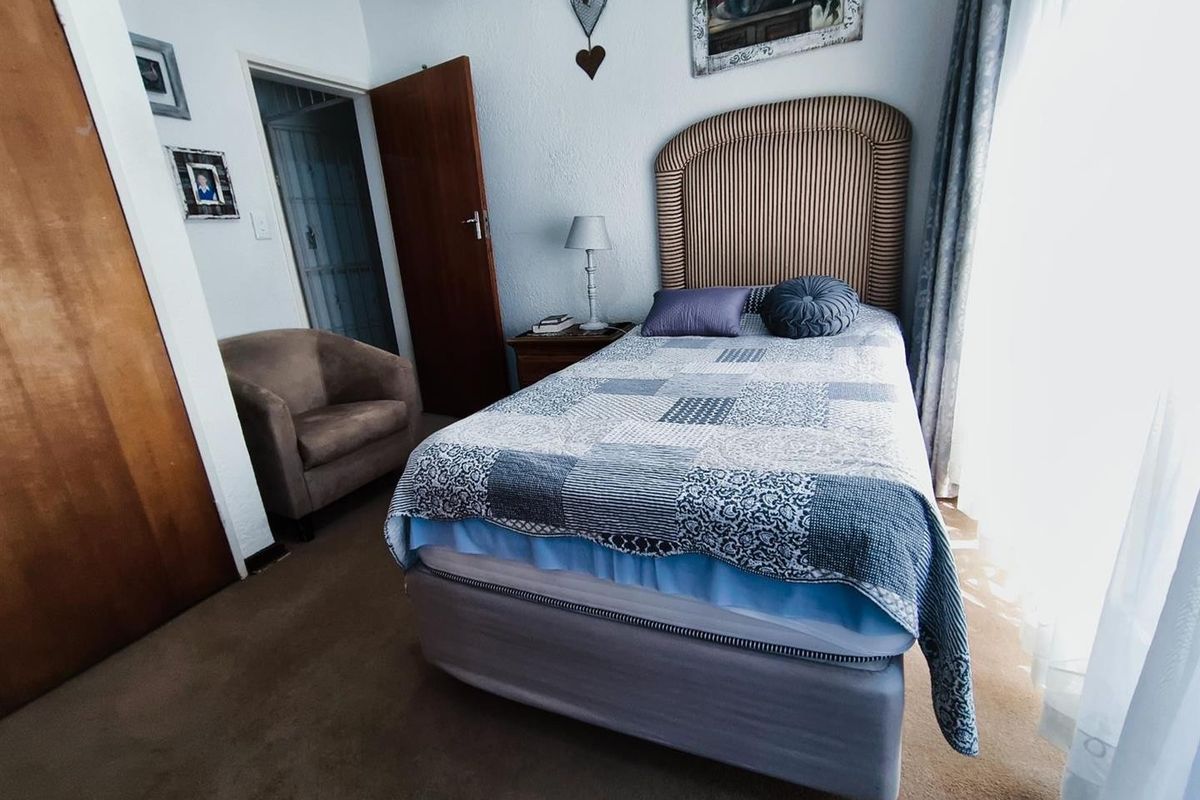 A cozy bedroom featuring built-in wooden cabinetry and carpeted flooring, offering a functional and comfortable living space.