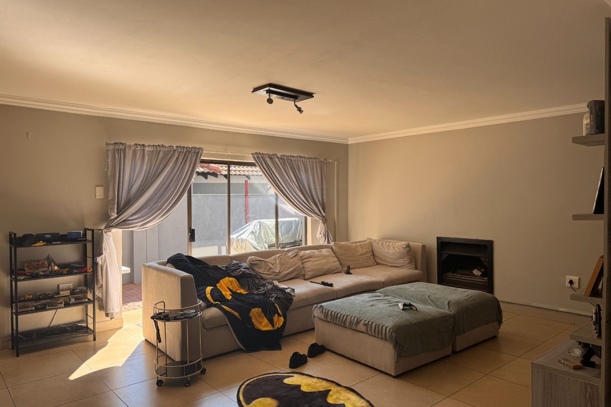 Spacious living room featuring tiled flooring, a built-in fireplace, and large sliding glass doors providing access to the outdoor area.