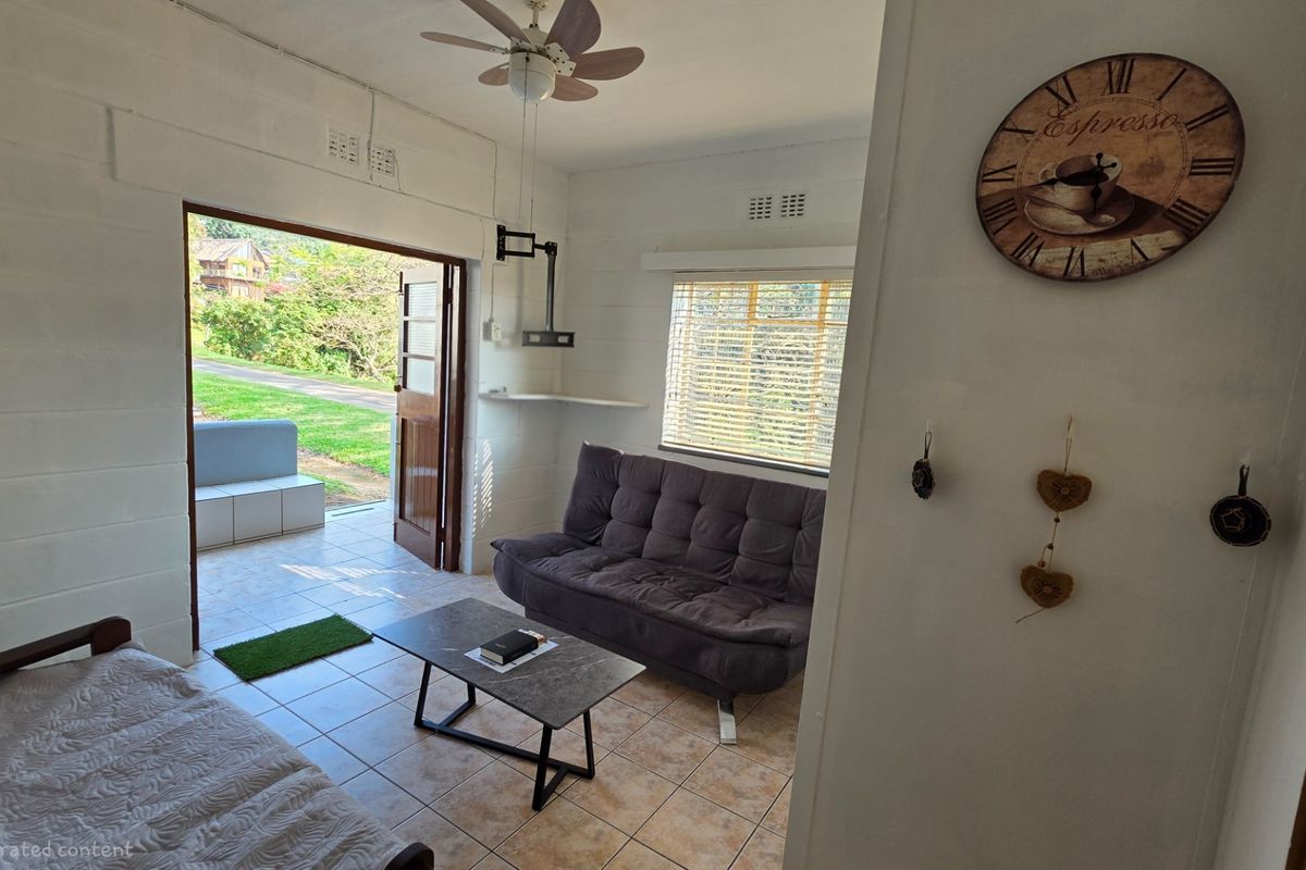 A living room featuring tiled flooring, a ceiling fan, and direct access to an outdoor patio area through a wooden door.