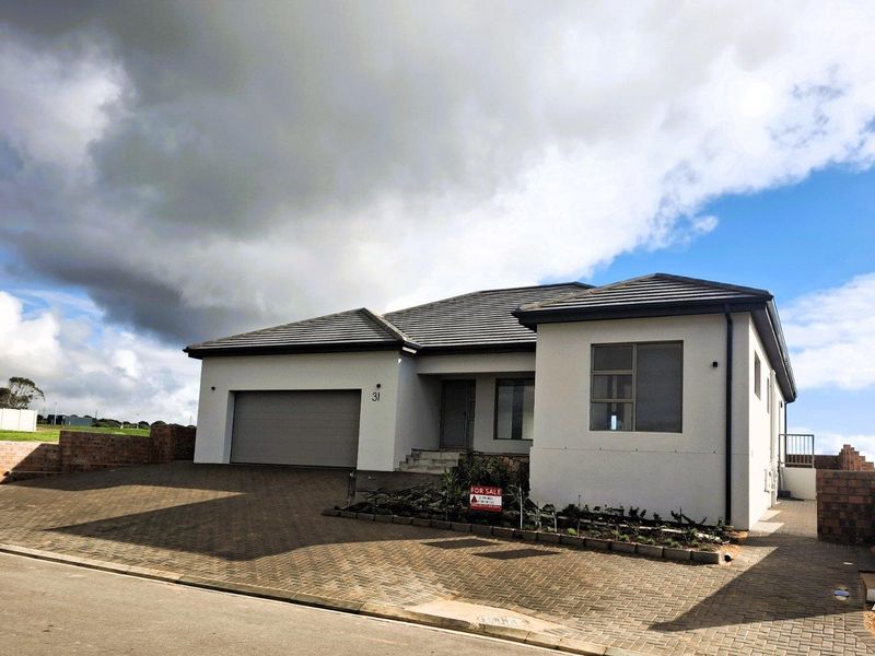 A modern single-story residential home featuring a paved driveway, double garage, and neutral exterior facade.