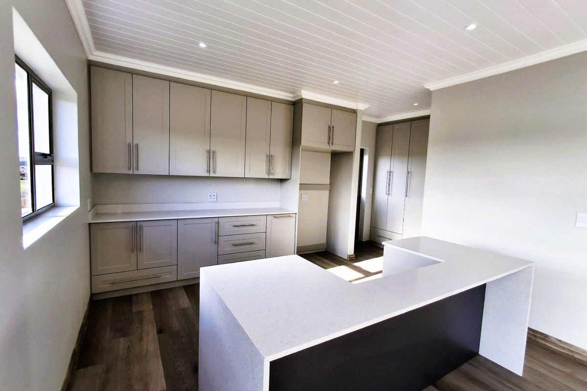 Modern kitchen featuring sleek cabinetry, stone countertops, a functional breakfast bar, and recessed ceiling lighting in a clean, contemporary space.