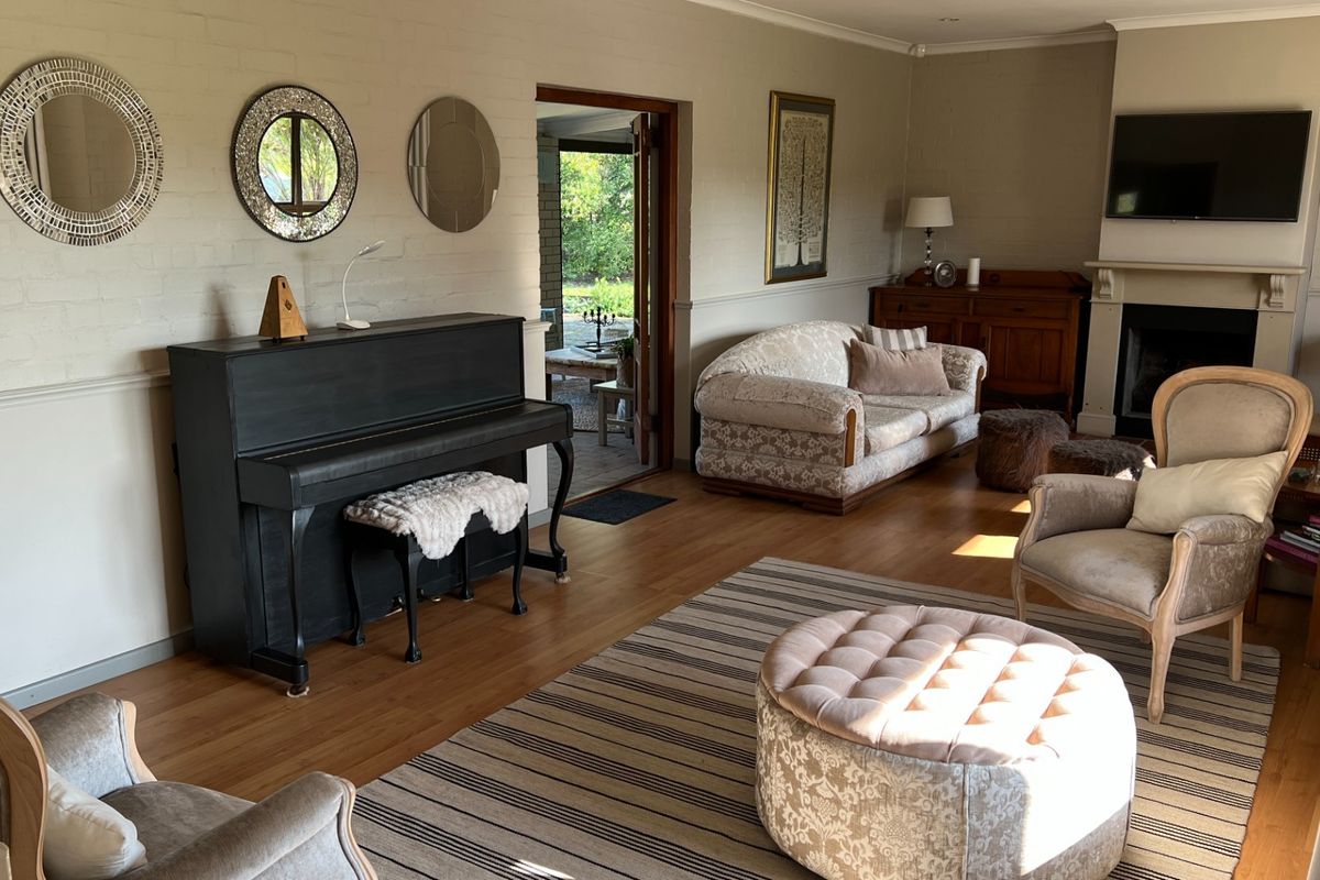 Spacious living room featuring a built-in fireplace, hardwood flooring, and direct access to an outdoor patio area.