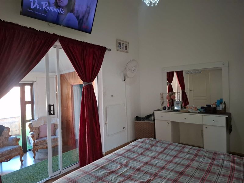 Bedroom featuring a sliding glass door leading to an outdoor patio area, wall-mounted fan, and built-in vanity unit.