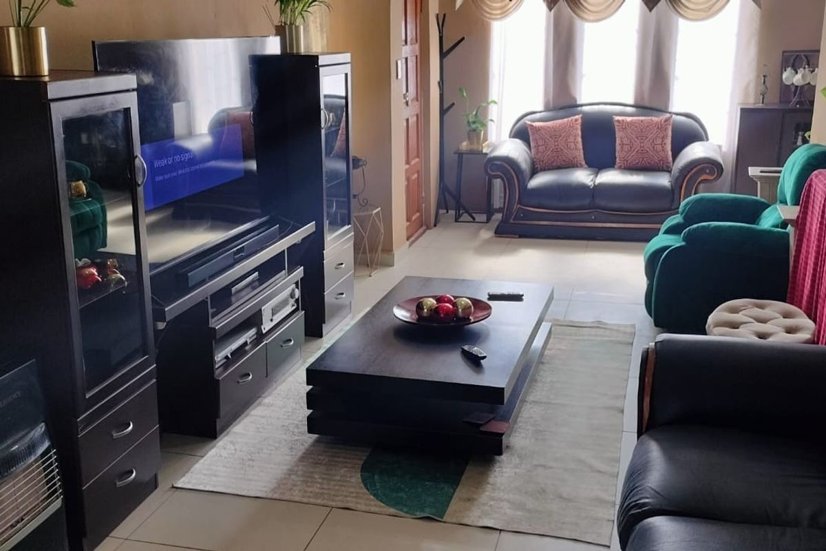 A comfortable living room featuring tiled flooring and large windows that allow for natural light.