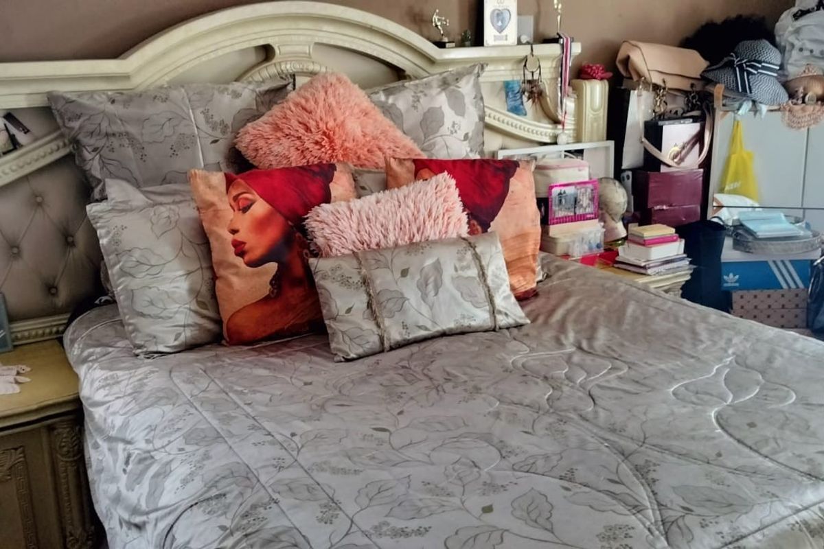 A bedroom featuring a built-in headboard and matching bedside cabinetry.